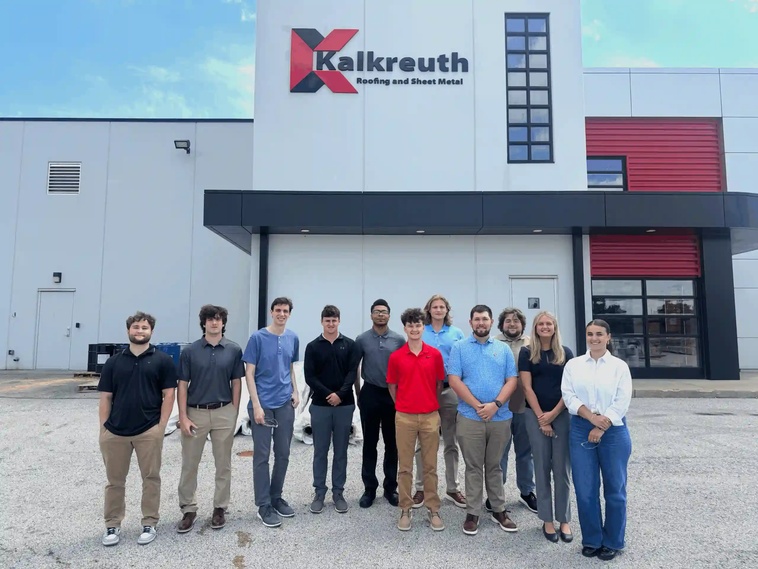 A group of employees stands in front of a Kalkreuth bulding